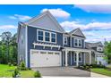 Attractive two-story home with a two-car garage, blue siding, and a well-maintained lawn, creating a welcoming curb appeal at 5036 Cambria Ct., Little River, SC 29566