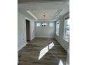 Bright dining room with luxury vinyl plank flooring, modern lighting fixture, and large windows at 622 Braselton Ln., Myrtle Beach, SC 29588