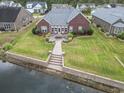 Backyard patio with an outdoor dining area overlooking a tranquil pond at 1066 Brentford Pl., Myrtle Beach, SC 29579