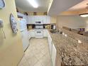 Clean kitchen featuring white appliances and granite countertops with bar stool seating at 2007 S Ocean Blvd. # 401, Myrtle Beach, SC 29577