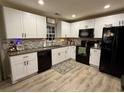 Modern kitchen featuring white cabinets, black appliances, granite countertops, and stylish backsplash at 276 Palmetto Glen Dr., Myrtle Beach, SC 29588