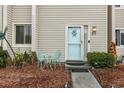 Light teal front door with starfish decor and small patio furniture at 951 Plantation Dr. # F1, Little River, SC 29566