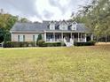 Beautiful two-story home boasting a spacious front porch, dormer windows, and a lush green lawn at 2347 Devine St., Georgetown, SC 29440