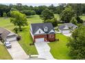 Aerial view of a red brick home on a lush lot backing onto a golf course at 428 Meadow View Ct., Longs, SC 29568