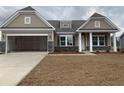 New construction home with a two-car garage and stone accents at 954 Oak Hollow St., Longs, SC 29568