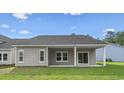 Rear view of the home featuring an outdoor patio space, lawn and windows at 9742 Indigo Creek Blvd., Murrells Inlet, SC 29576