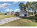 View of a single Gathering home with a well-maintained lawn and driveway at 603 Bucks Trail, Longs, SC 29568