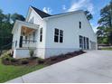 Side view of a bright, white home with an attached garage and manicured landscaping at 805 Comanders Island Rd., Georgetown, SC 29440