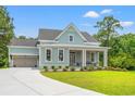 Charming single-Gathering home with blue siding, a welcoming front porch, and a well-manicured lawn at 852 Comanders Island Rd., Georgetown, SC 29440