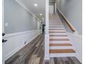 Bright hallway featuring stylish wood floors, wainscoting, and staircase with wood railing at 1010 Club House Dr., North Myrtle Beach, SC 29582