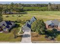 Aerial view of a home with a well-manicured lawn, close to a golf course and green spaces at 565 Bucks Trail, Longs, SC 29568