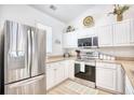 Well-lit kitchen showcases stainless steel refrigerator and stove along with white cabinets and light countertops at 601 Hillside Dr. N # 4133, North Myrtle Beach, SC 29582