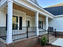 Side view of the front porch shows white columns and a wood ceiling at 909 Grimes St., Georgetown, SC 29440