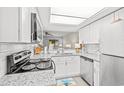 Modern kitchen featuring white shaker cabinets, granite countertops, and stainless steel appliances at 23 Shadow Moss Pl. # 23, North Myrtle Beach, SC 29582