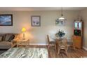 Cozy dining area with a glass table, wooden chairs, and beach-themed artwork on the walls at 1095 West Plantation Dr. # 28-I, Little River, SC 29566