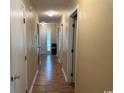 Bright hallway with wood-look flooring and white trim, leading to a welcoming front door at 1095 West Plantation Dr. # 28-I, Little River, SC 29566