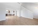 Open-concept living room showcasing hardwood floors and a view into the well-lit kitchen and staircase at 2469 Campton Loop, Conway, SC 29527
