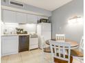 Cozy kitchen with white appliances, breakfast table, and tile flooring at 5523 N Ocean Blvd. N # 1410, Myrtle Beach, SC 29577