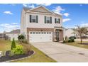 Charming home with a two-car garage, neatly landscaped yard, and a welcoming blue front door at 568 Affinity Dr., Myrtle Beach, SC 29588