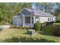 Low angle of the charming gray home displaying manicured landscaping and an American flag at 138 Sugar Loaf Ln., Murrells Inlet, SC 29576