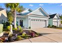 Quaint, light blue home with a two-car garage, inviting curb appeal, and a beautifully landscaped front yard at 1604 Carsens Ferry Dr., Conway, SC 29526