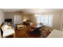 Bright living room with hardwood floors, ceiling fan, and natural light streaming through the large bay window at 425 Spauldingwood Rd., Little River, SC 29566