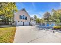 View of the home's exterior showcasing a multi-car garage, driveway, and fenced in pool area at 437 N Boyle Dr., Pawleys Island, SC 29585