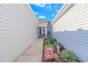 Cozy walkway adorned with vibrant autumn decor, statue and lush greenery leading to the front door at 830 San Marco Ct. # C, Myrtle Beach, SC 29579