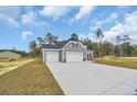 View of house featuring large driveway, a two-car garage, and manicured front lawn at 240 Palmetto Sand Loop, Conway, SC 29527