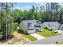 Aerial view of a two-story home with a spacious lawn, long driveway, and lush green trees surrounding the property at 604 Mccown Dr., Conway, SC 29526