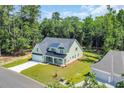 Aerial view of a two-story home with a spacious lawn, a lush green forest and neighborhood surrounding the property at 604 Mccown Dr., Conway, SC 29526
