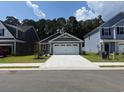 A charming single-Gathering home featuring a two-car garage, complemented by a well-manicured lawn and driveway at 1028 Oak Meadow Dr., Conway, SC 29526