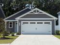 Charming single Gathering home featuring a two-car garage, white trim and a well-manicured lawn at 1028 Oak Meadow Dr., Conway, SC 29526