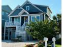 Inviting home exterior with elevated deck, white railings, and landscaped yard near the beach at 253 W Second Ave. S, Ocean Isle Beach, NC 28469