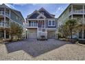Charming raised beach home with a white stone driveway at 253 W Second Ave. S, Ocean Isle Beach, NC 28469