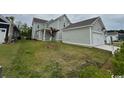 Home exterior view featuring a detached garage and a neatly maintained lawn at 718 Macon Alley, Myrtle Beach, SC 29588