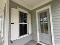 Inviting front porch featuring a gray front door and white trim windows at 718 Macon Alley, Myrtle Beach, SC 29588
