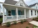Inviting home with a spacious covered porch, stylish blue accents, and well-maintained exterior at 734 Macon Alley, Myrtle Beach, SC 29588