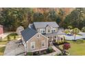 Aerial view of a tan home with a black metal roof, pool, outbuildings, and lush landscaping at 104 Chapel Ridge Circle, Myrtle Beach, SC 29588