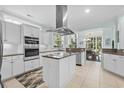Bright kitchen featuring an island cooktop, stainless appliances, white cabinetry and large windows at 5012 Lindrick Ct., Myrtle Beach, SC 29579