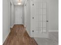 Bright hallway featuring wood floors, white walls, and doors, leading to other rooms in the home at 2412 Campton Loop, Conway, SC 29527