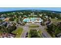 Aerial view of a community pool and clubhouse surrounded by lush landscaping and mature trees at 700 Lapwind Loop, Myrtle Beach, SC 29579