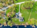 Aerial view of property on lake with multiple outbuildings, and a long driveway entrance at 865 River Rd., Tabor City, NC 28463