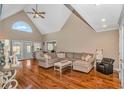 Bright living room with a soaring ceiling, large arched window and hardwood floors at 865 River Rd., Tabor City, SC 28463