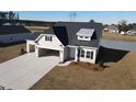 Rear exterior view of a two-story home with a two-car garage, driveway, and lawn at 1038 Jase Dr., Longs, SC 29568