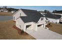 Rear exterior view of a two-story home showing a two-car garage, driveway, and lawn at 1038 Jase Dr., Longs, SC 29568
