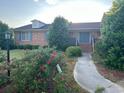 Charming brick home with a welcoming entrance and blue shutters framed by mature landscaping at 1692 S Morgan Ave., Andrews, SC 29510