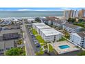 Aerial view of condo community with ocean view, pool, and ample parking in a coastal setting at 191 Maison Dr. # B203, Myrtle Beach, SC 29572
