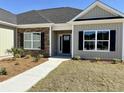 Close-up of a home's front entrance with stone accents and well manicured landscaping at 217 Shady Pines Ct., Conway, SC 29527