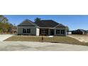 Inviting single-story home with stone accents, black shutters, and a well-manicured lawn at 217 Shady Pines Ct., Conway, SC 29527